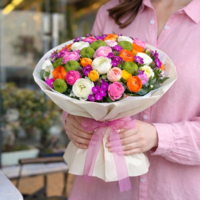 Renkli ranunkulus �i�eklerinden olu�an, krem ambalajl� ve pembe kurdeleli ��k buket